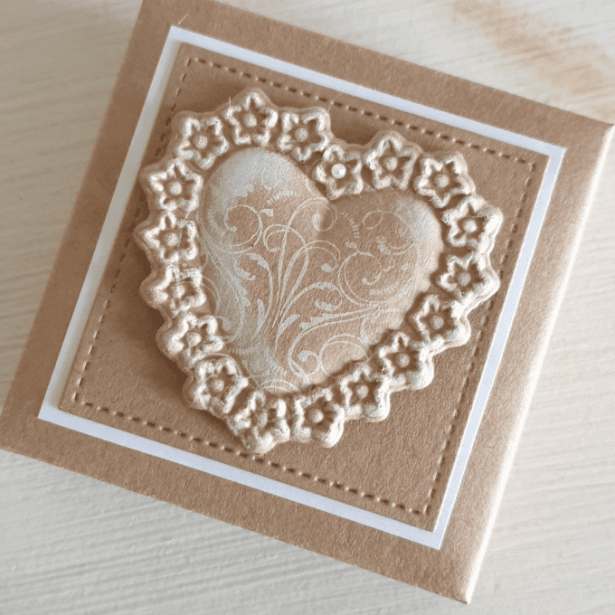 Boîte cadeau décorée d’un cœur fleuri contenant des pétales de savons artisanaux.