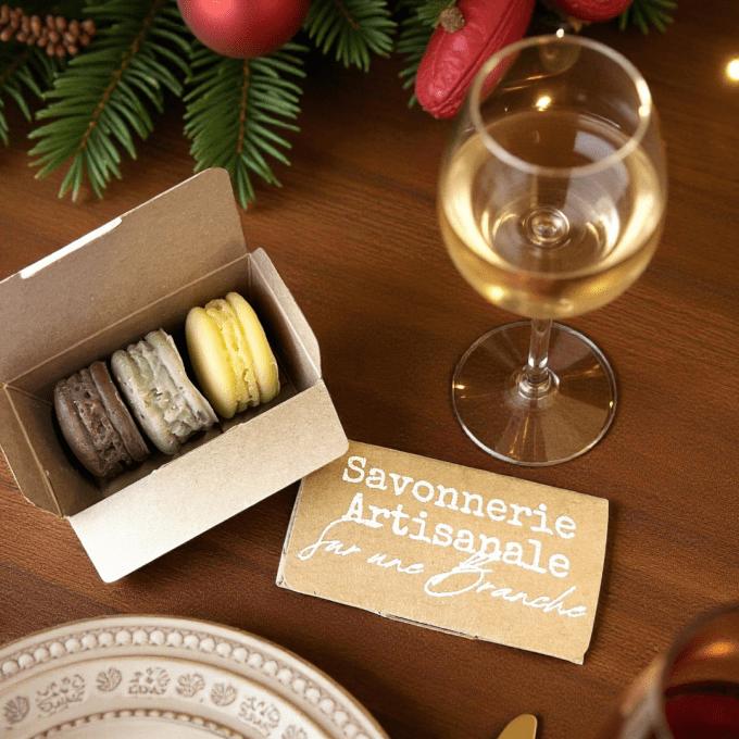 Coffret kraft contenant trois macarons de savon artisanaux Sur une Branche, disposé sur une table de