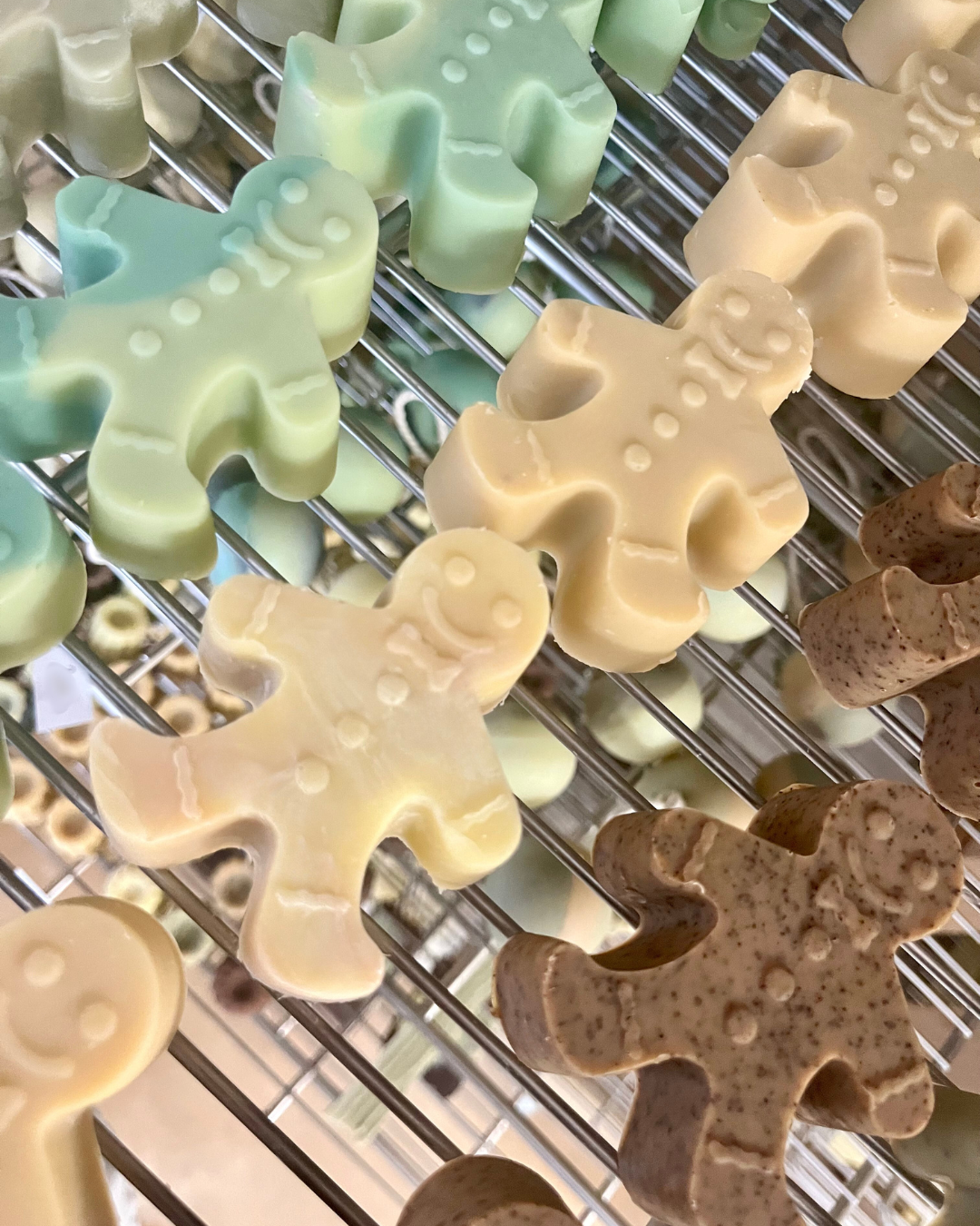 Savons saponifiés à froid en forme de petits bonhommes de pain d’épices, fabriqués à la main par la savonnerie Sur une Branche. Parfumés aux huiles essentielles naturelles, ils sèchent sur les grilles de l’atelier avant d’être préparés pour les fêtes de Noël.